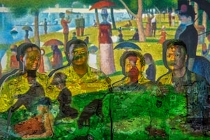 Capt. Wilmine T. Simon, Tech Sgt. Benson Berdy Jean, Lt. Col. Jacqueline Garcia-Castellanos, and Capt. Robert Tang Bau (left to right), 482d Medical Squadron, poses in front of a projection of Georges Seurat's painting "A Sunday Afternoon on the Island of La Grande Jatte" at Homestead Air Reserve Base on January 7, 2024.