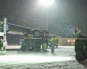 Two Airmen assigned to the 5th Maintenance Group move hazard cones during Exercise Prairie Vigilance/Bayou Vigilance (PV/BV) 24-2 at Minot Air Force Base, North Dakota, Jan. 5, 2024. Exercises such as PV/BV ensure Team Minot Airmen stay proficient in a variety of key operational skills. (U.S. Air Force photo by Senior Airman Evan Lichtenhan)