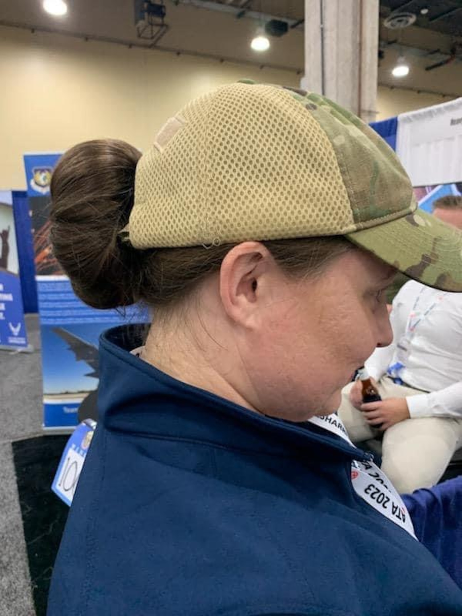 A member of the 436th Airlift Wing demonstrates how a bun fits into the newly designed unisex bump cap at the Airlift/Tanker Association Conference in Grapevine, Texas Nov. 9, 2023. The new bump cap was created by U.S. Air Force Staff Sgt. Sheila Moody, 436th Aircraft Maintenance Squadron Air Force Repair Enhancement Program aircraft structural journeyman and U.S. Air Force Staff Sgt. Cortnee Madrid, 436th Aircraft Maintenance Squadron dock chief. (U.S. Air Force photo by Staff Sgt. Sheila Moody)