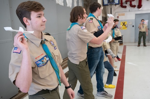 A scout launches his handmade foam glider during a competition with his fellow scouts.