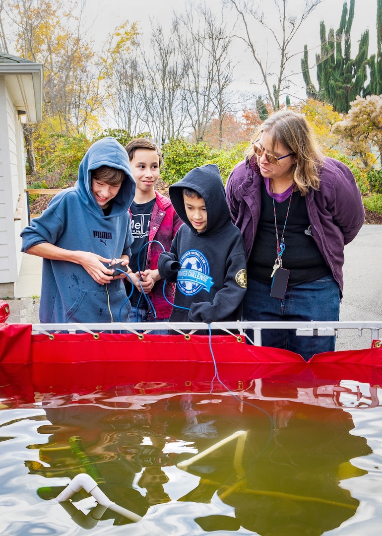 Dianna Palermo, Puget Sound Naval Shipyard & Intermediate Maintenance Facility, STEM outreach coordinator, watches as local fourth and fifth grade students from Silver Ridge Elementary School, test drive their student-constructed underwater remotely operated vehicles during STEM Days activities Nov. 15, 2023, at the Puget Sound Navy Museum, in Bremerton Washington. (U.S Navy Photo by Wendy Hallmark)