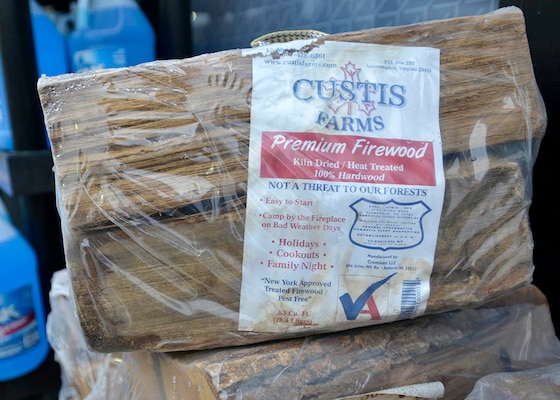 Bundle of plastic wrapped firewood with label on it.