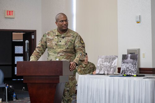 Lt. Col Jared Gilmer stands behind a podium and addresses the panelists at the Martin Luther King Jr. birthday panel.