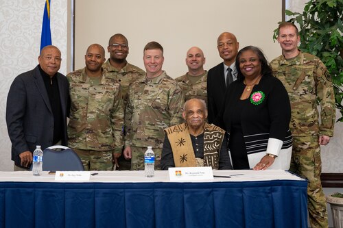 Panelists pose for a photo behind the panel desk.