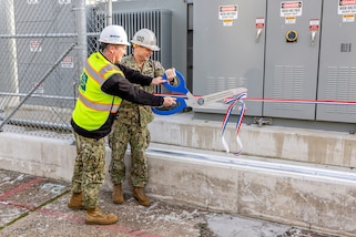 Capt. JD Crinklaw, commander, Puget Sound Naval Shipyard &
Intermediate Maintenance Facility, and Capt. Brent Paul, commander, Naval Facilities Engineering Systems Command, Northwest, cut the ribbon for a new substation near Dry dock 4 at the shipyard in Bremerton, Washington, Nov. 20, 2023. (U.S. Navy photo by Jeb Fach)