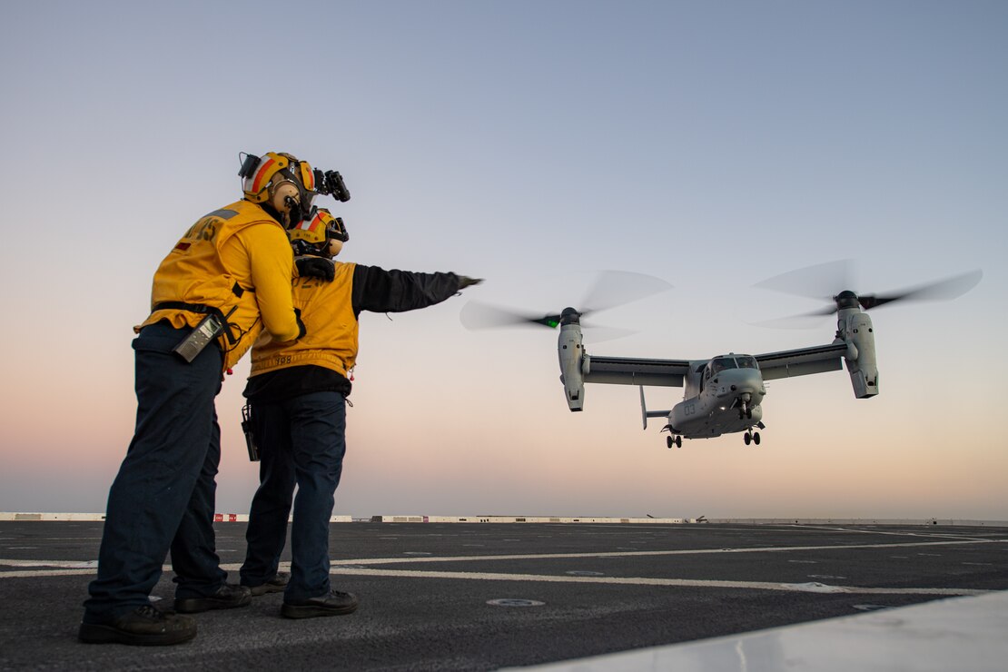 Aviation Boatswain’s Mate (Handling) 3rd Class Michael Aguilar, a native of Glendale, California, left, supports Aviation Boatswain’s Mate (Handling) 3rd Class Sydney Chavez, a native of Estancia, New Mexico, as she signals an MV-22B Osprey, assigned to the “White Knights” of Marine Medium Tiltrotor Squadron (VMM) 165 (Reinforced), during flight quarters aboard USS Somerset (LPD 25), Oct. 29, 2023. Somerset is a San Antonio-class amphibious transport dock ship currently underway in the U.S. 3rd Fleet area of operations. (U.S. Navy Photo by Mass Communication Specialist 2nd Class Evan Diaz)