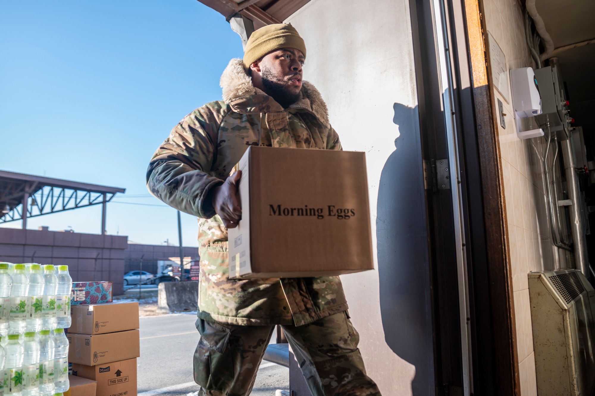 U.S. Air Force Senior Airman Kevin Jones, 51st Force Support Squadron food services journeyman, carries supplies into the flightline dining facility at Osan Air Base, Republic of Korea, Jan. 8, 2024. The facility serves Airmen daily to ensure that personnel have a convenient place to eat, enabling them to swiftly return to their critical tasks. (U.S. Air Force photo by Senior Airman Trevor Gordnier)