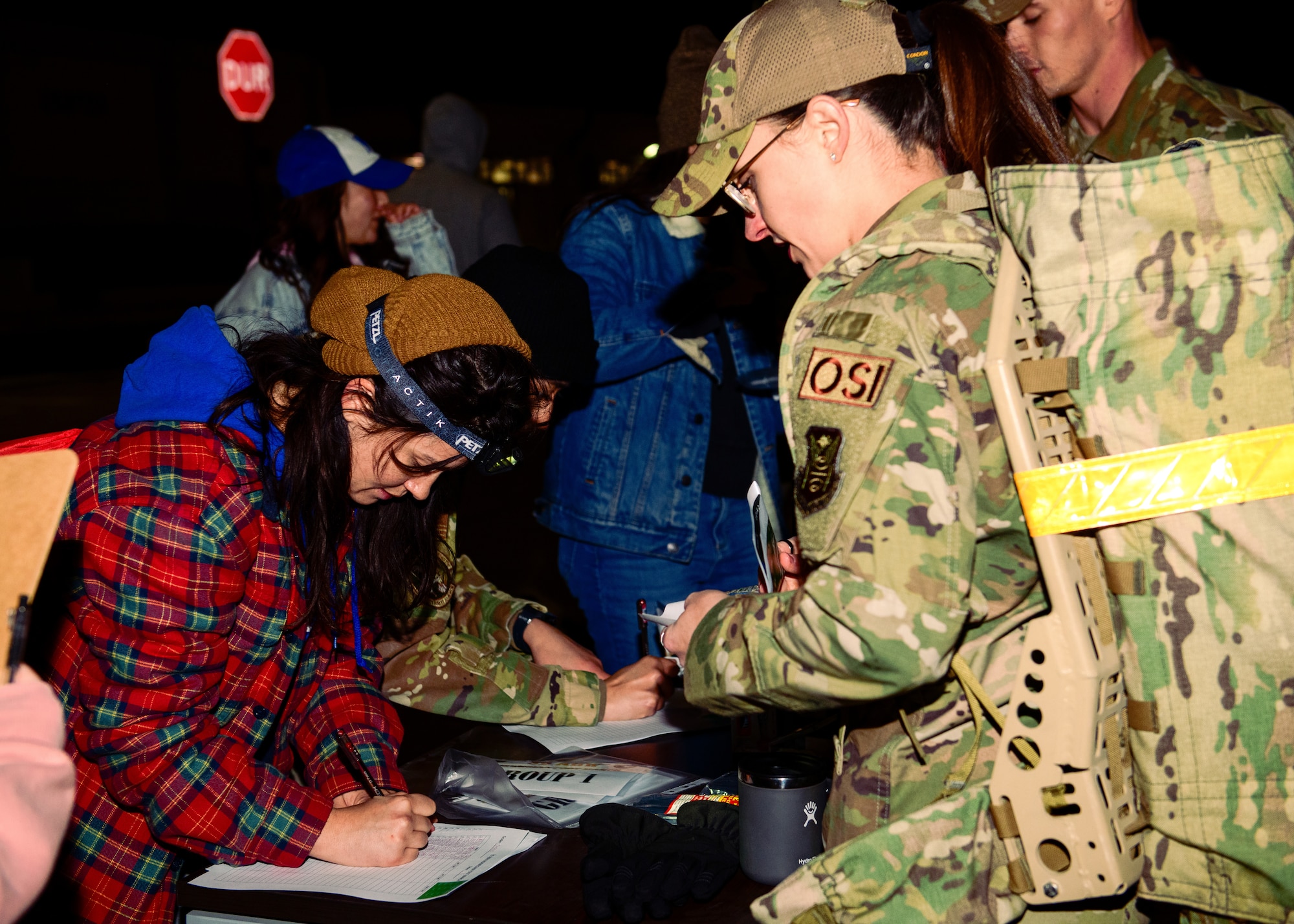 An event volunteer records information from an Airman participating in a Norwegian Foot March