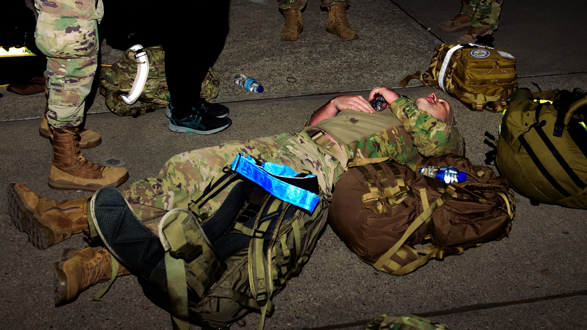 An Airman lays on the ground after completing the Norwegian Foot March