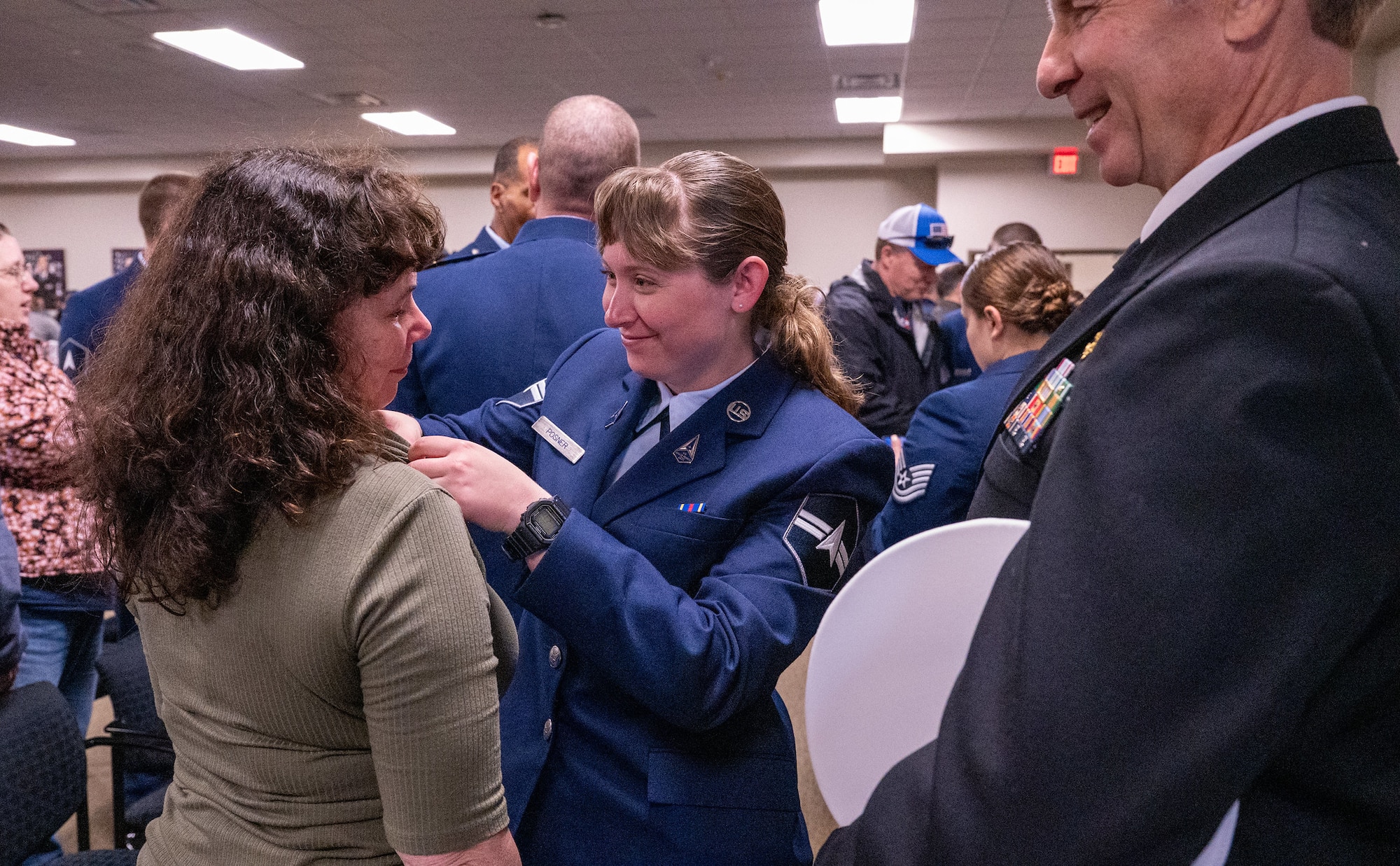 A newly graduated U.S. Space Force Guardian presents the U.S. Space Force Family lapel pin to a family member during a Basic Military Training graduation ceremony at Joint Base San Antonio-Lackland, Texas, Dec. 27, 2023. In a move that celebrates both the service members and their families, graduating Guardians will now present the Delta-shaped U.S. Space Force Family lapel pins to their loved ones during graduation week. (U.S. Air Force photo by 2d Lt. Kate E. Anderson)