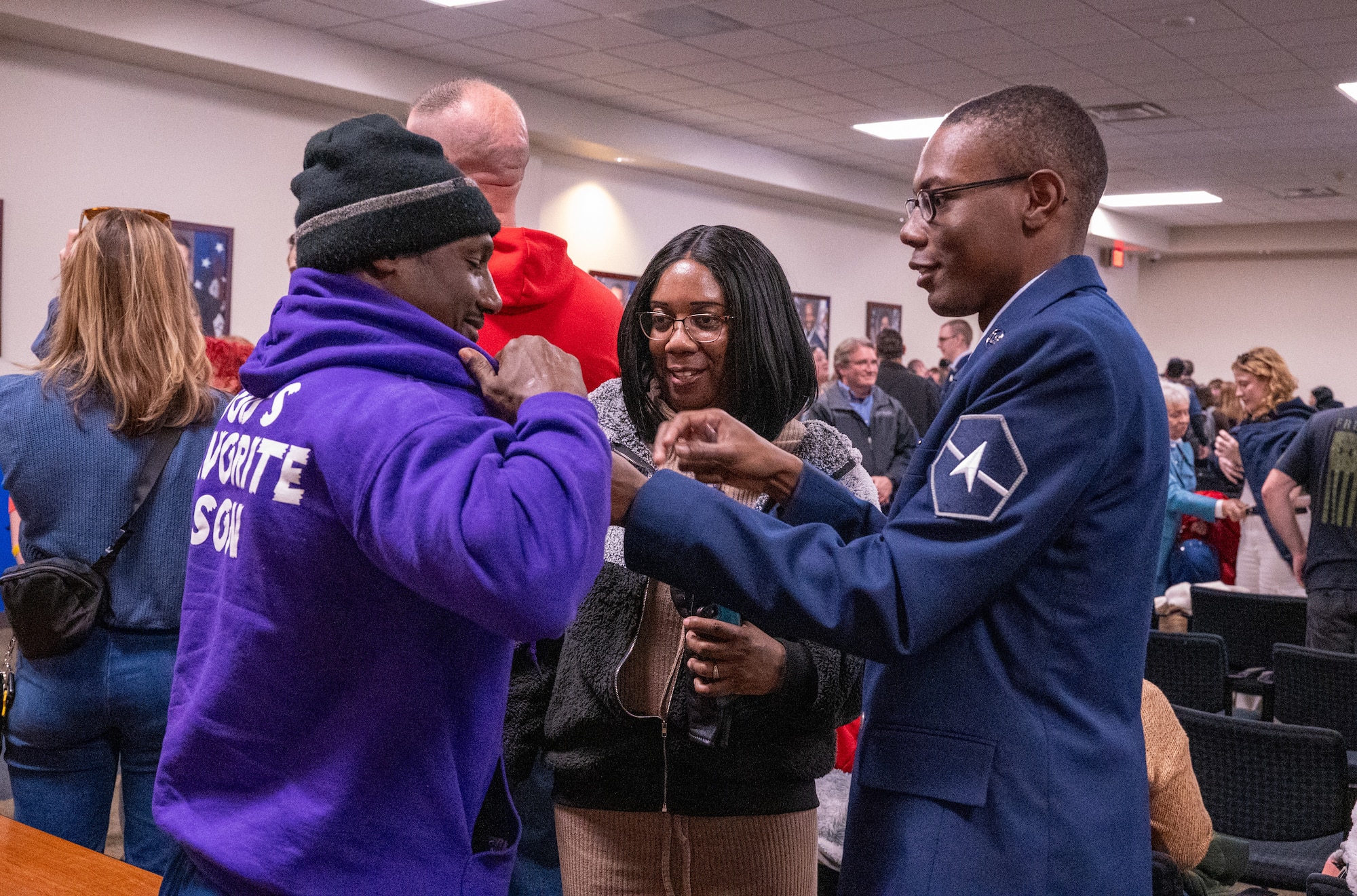 A newly graduated U.S. Space Force Guardian presents the U.S. Space Force Family lapel pin to a family member during a Basic Military Training graduation ceremony at Joint Base San Antonio-Lackland, Texas, Dec. 27, 2023. In a move that celebrates both the service members and their families, graduating Guardians will now present the Delta-shaped U.S. Space Force Family lapel pins to their loved ones during graduation week. (U.S. Air Force photo by 2d Lt. Kate E. Anderson)