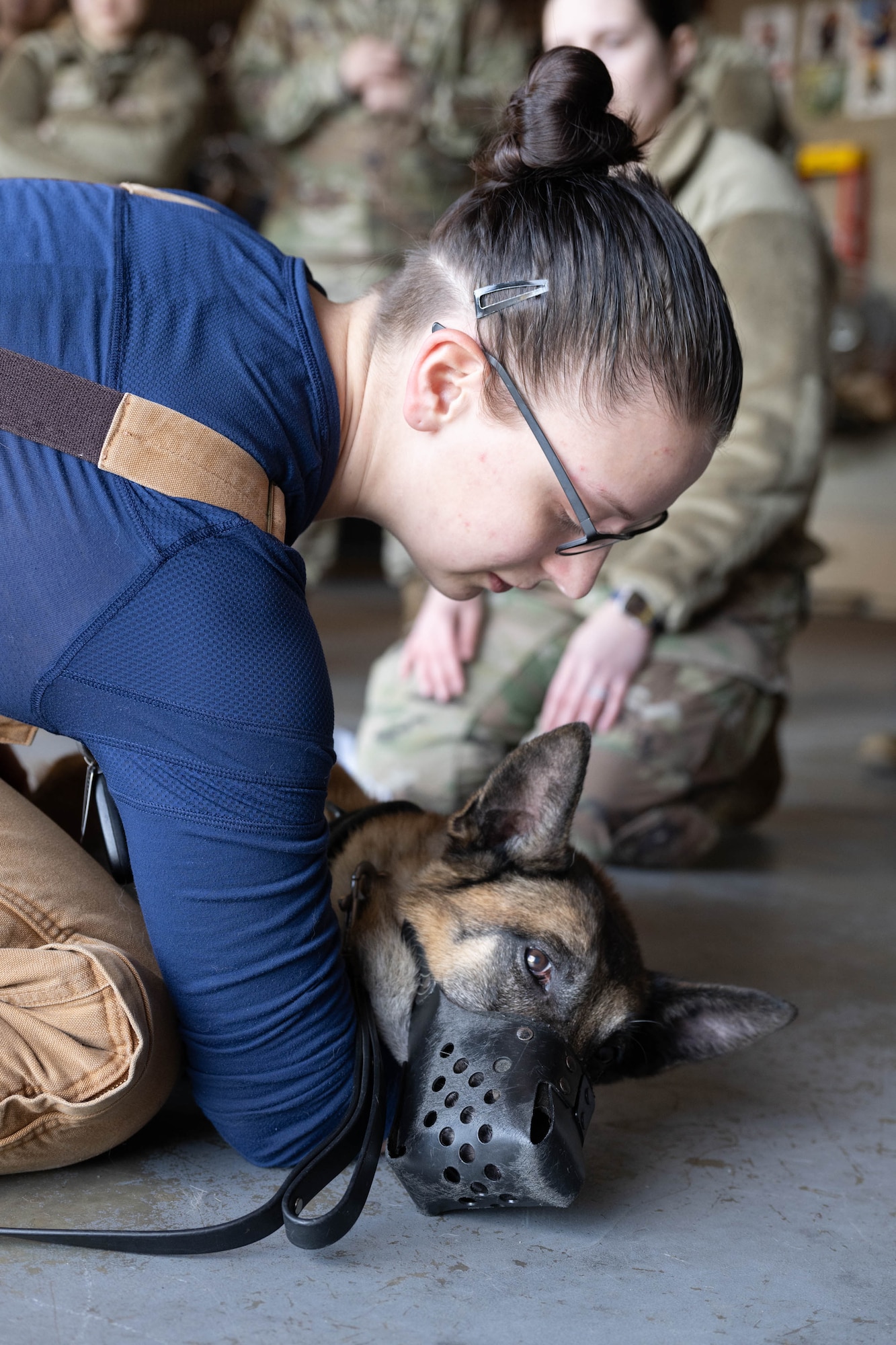 U.S. Air Force Senior Airman Courtney Burns, 436th Security Forces Squadron military working dog handler, demonstrates proper restraining techniques on MWD Zorro during a training session at Dover Air Force Base, Delaware, Jan. 10, 2024. Members of the 436th SFS MWD section along with the Dover AFB Veterinary Treatment Facility and the 436th Medical Group Warm Zone team held a joint training session to practice the skills necessary to decontaminate MWDs and possibly save their lives in the aftermath of a nuclear, biological or chemical attack or spill. (U.S. Air Force photo by Mauricio Campino)