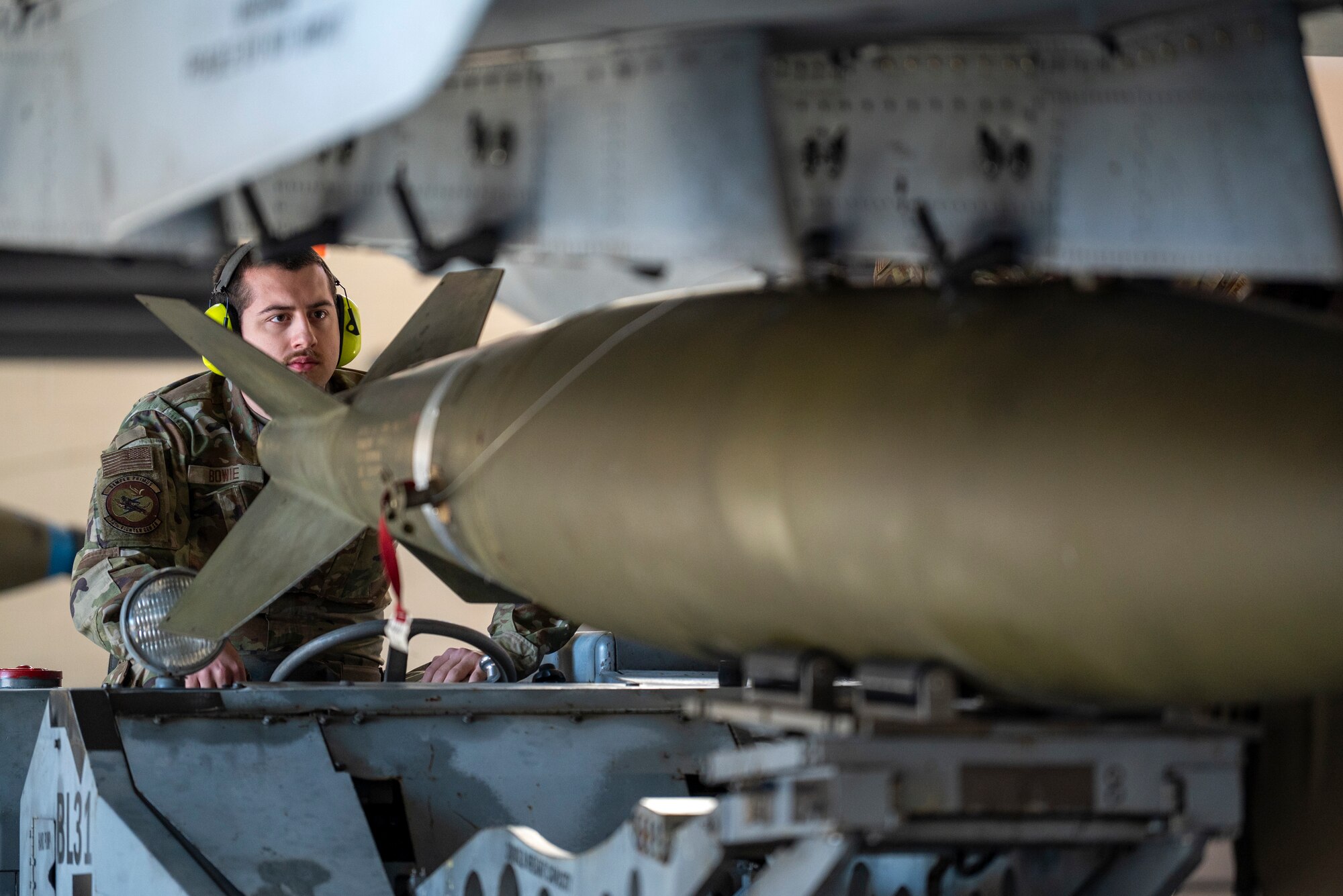 U.S. Air Force Airman 1st Class Aaron Bowie, 74th Fighter Generation Squadron load crew member, raises a munition with a specialized lift under an A-10C Thunderbolt II at Moody Air Force Base, Georgia, Jan. 5, 2024. Precision, safety and speed are critical in real-world implementation and essential to winning a load competition. (U.S. Air Force photo by Airman 1st Class Leonid Soubbotine)