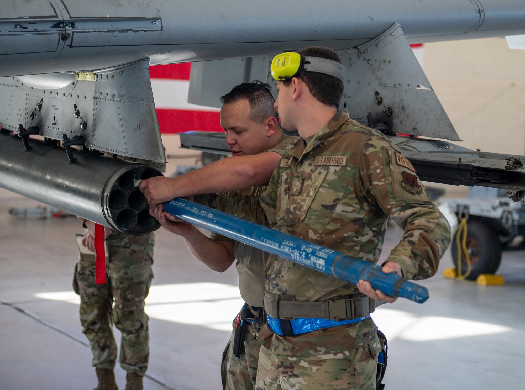 U.S. Air Force Staff Sgt. Concepcion Rodelo (left) and Airman 1st Class Aaron Bowie (right), 74th Fighter Generation Squadron load crew members, load a missile pod on an A-10C Thunderbolt II at Moody Air Force Base, Georgia, Jan. 5, 2024. Two three-man teams competed against each other while loading munitions onto the aircraft. (U.S. Air Force photo by Airman 1st Class Leonid Soubbotine)