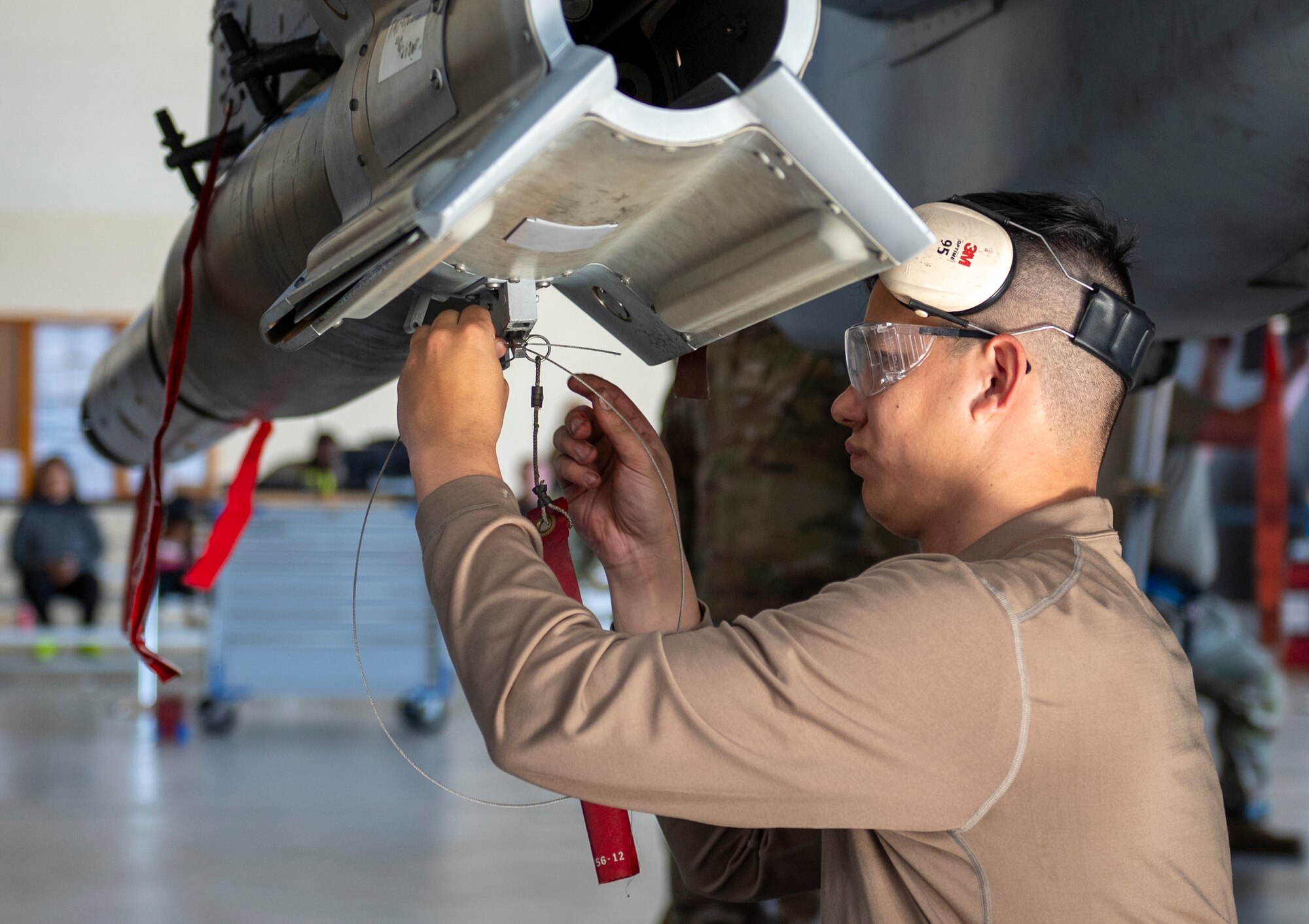 U.S. Air Force Senior Airman Dylan Gleason-Pritts, 74th Fighter Generation Squadron load crew member, works on a missile at Moody Air Force Base, Georgia, Jan. 5, 2024. Efficient and safe weapon-loading procedures are crucial to getting jets in the air to accomplish the mission. (U.S. Air Force photo by Airman 1st Class Leonid Soubbotine)