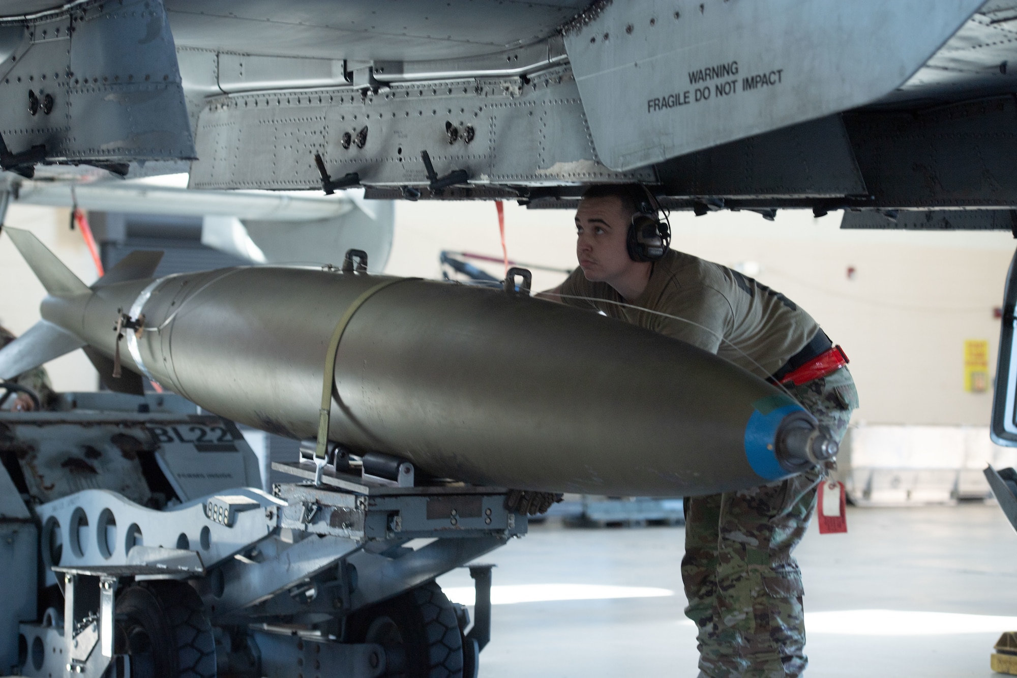 U.S. Air Force Staff Sgt. Kyler Wilson, 75th Fighter Generation Squadron load crew member, assists with loading an A-10C Thunderbolt II for a quarterly weapons load competition at Moody Air Force Base, Georgia, Jan 5, 2024. The competition is a timed exercise where Airmen are tested on how quickly and efficiently they can load munitions onto an aircraft. (U.S. Air Force photo by Airman Cade Ellis)
