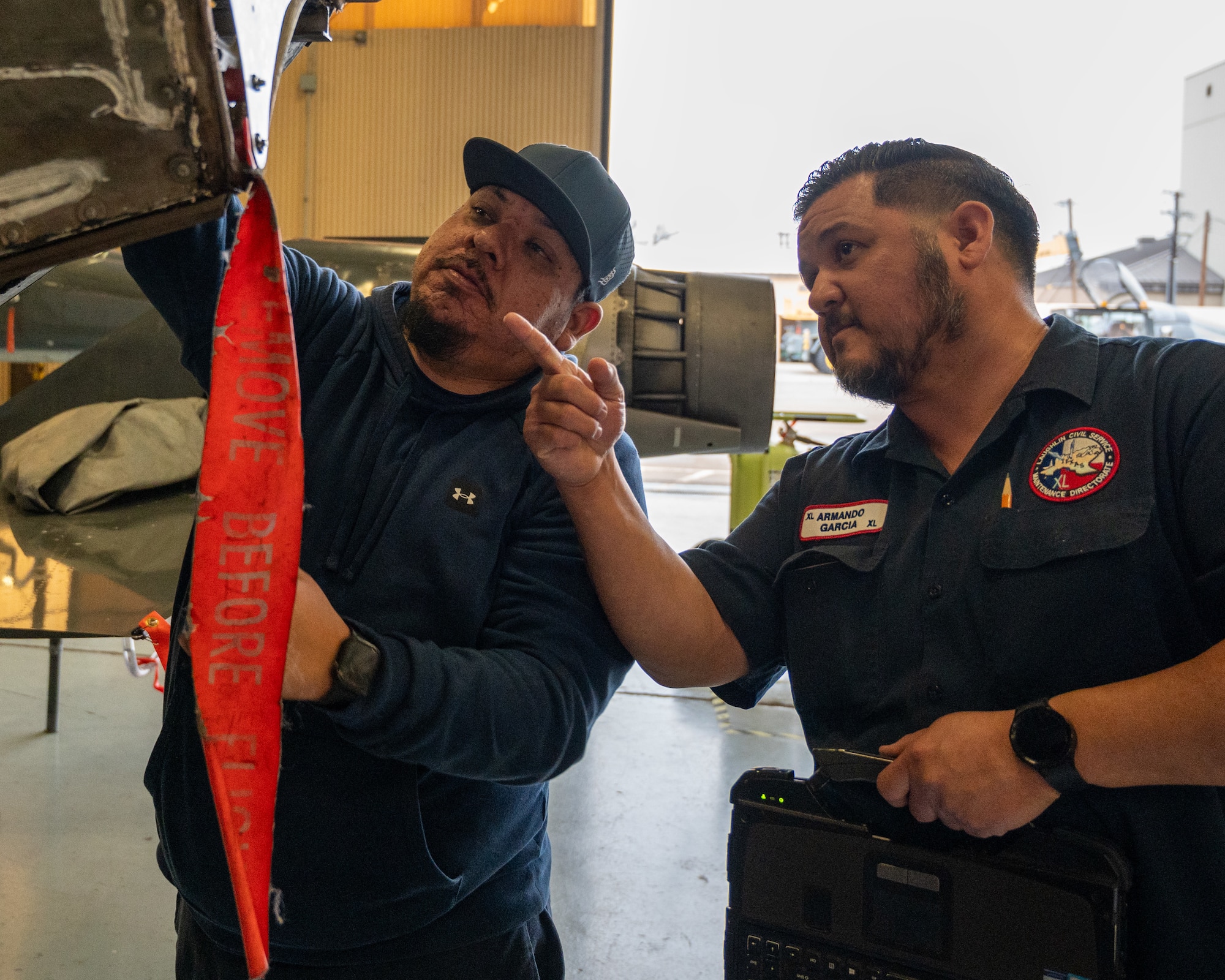 Armando Garcia (right), 47th Maintenance Directorate maintainer, discusses what maintenance will need to be done to the engine bay of a T-38C Talon while mentoring Luis Martinez (left), 47th MXD maintainer, at Laughlin Air Force Base, Texas, Jan. 8, 2024. Mentorship in the workplace is vital for efficient and smooth operations, as proper leadership brings the workplace together. During National Mentoring Month the Air Force is holding multiple live and virtual mentorship events to help develop Airmen and Guardians (U.S. Air Force photo by Staff Sgt. Nicholas Larsen)