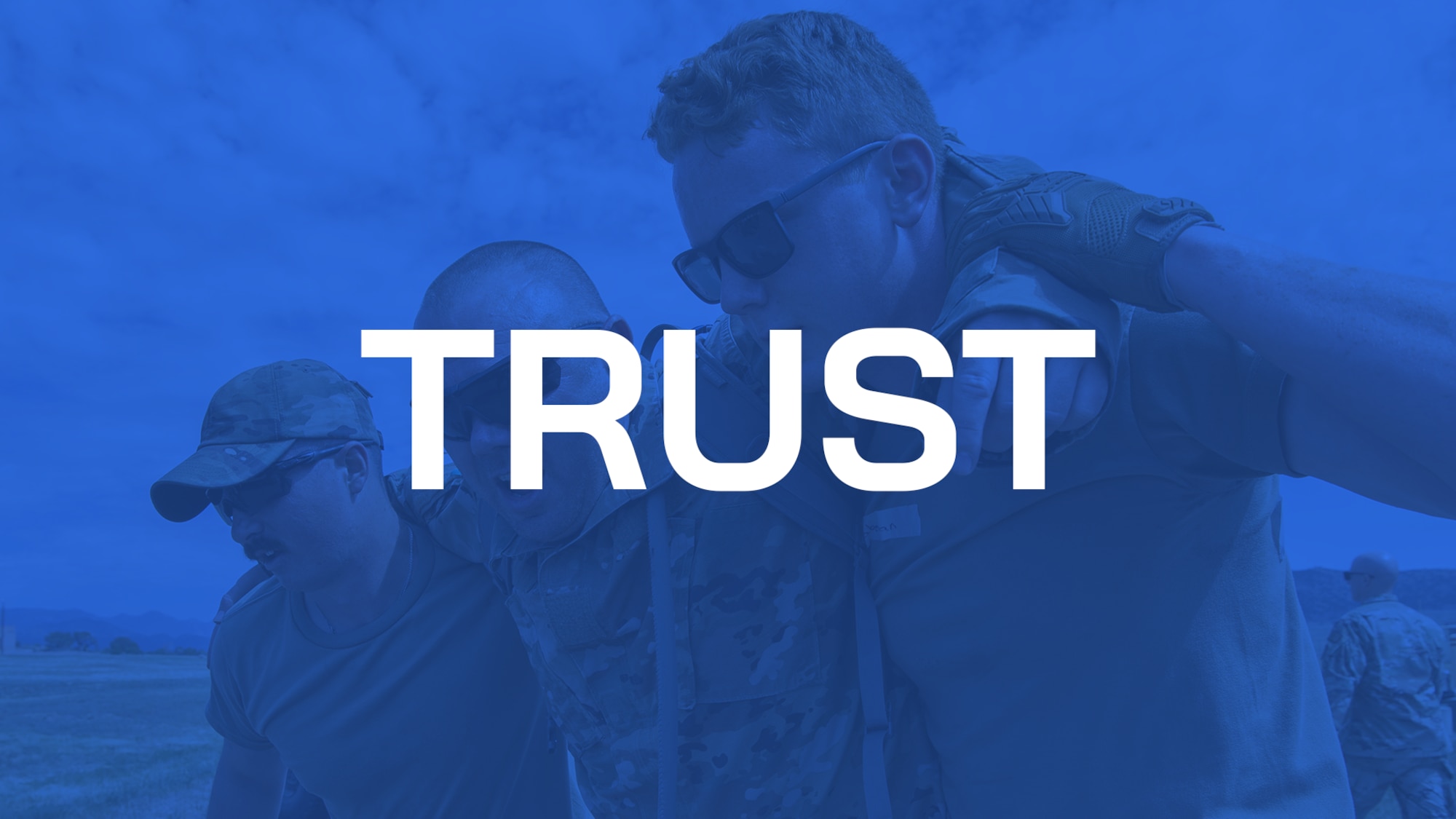 The word "TRUST" in capital letters with three servicemembers arm in arm with a blue overlay coloring the image.