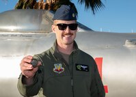 U.S. Air Force Maj. Stephen Keck, F-15E pilot assigned to the 53rd Wing, showcases the 2022 Mackay Trophy coin he received for completing the most meritorious flight of 2022 at Nellis Air Force Base, Nev., Jan. 11, 2024. Awarded by the Chief of Staff of the Air Force annually, the MacKay Trophy is one of the longest-standing aviation awards in the nation and was first awarded to 2nd Lt. Henry H. ‘Hap’ Arnold in 1912. (U.S. Air Force photo by Airman 1st Class Jordan McCoy)