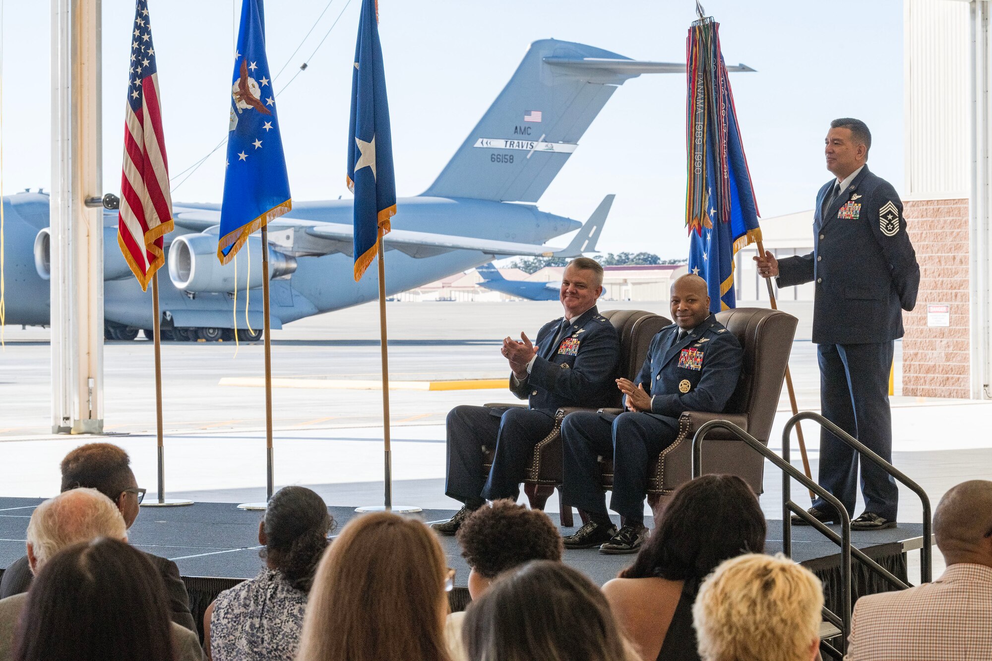 Maj. Gen. D. Scott Durham, 4th Air Force commander, passes the guidon to Col. Patrick L. Brady-Lee (right) as he assumes command of the 349th Air Mobility Wing on January 7, 2024, at Travis Air Force Base, California. (US Air Force photo by Tech. Sgt. Ryan Green)