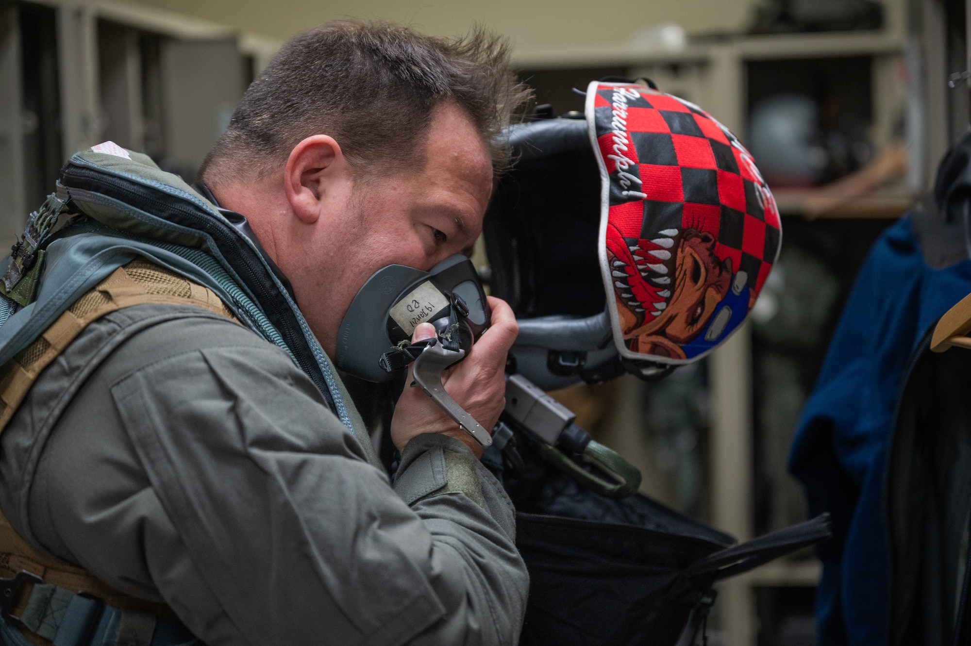 U.S. Air Force Lt. Col. Alexis Scott, 36th Fighter Squadron pilot, tests the breathing apparatus on his flight helmet at Osan Air Base, Republic of Korea, Jan. 9, 2024. The 36th FS trains regularly to ensure that the pilots maintain the skills necessary to deter any potential threats. (U.S. Air Force photo by Airman 1st Class Chase Verzaal)