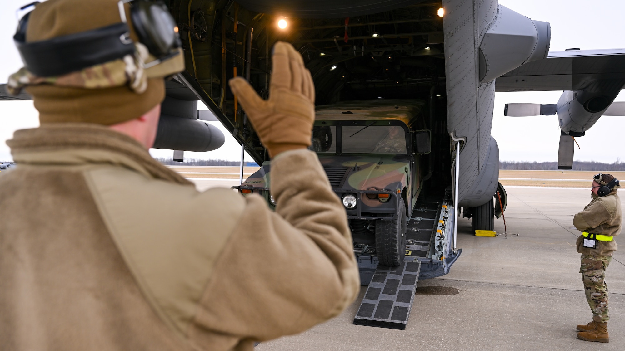 A pack of aerial porters with the 46th Aerial Port Squadron, Dover Air Force Base, Delaware, unload a Humvee from the cargo bay of a C-130H Hercules aircraft stationed at Youngstown Air Reserve Station, Ohio, on Jan. 6, 2024.