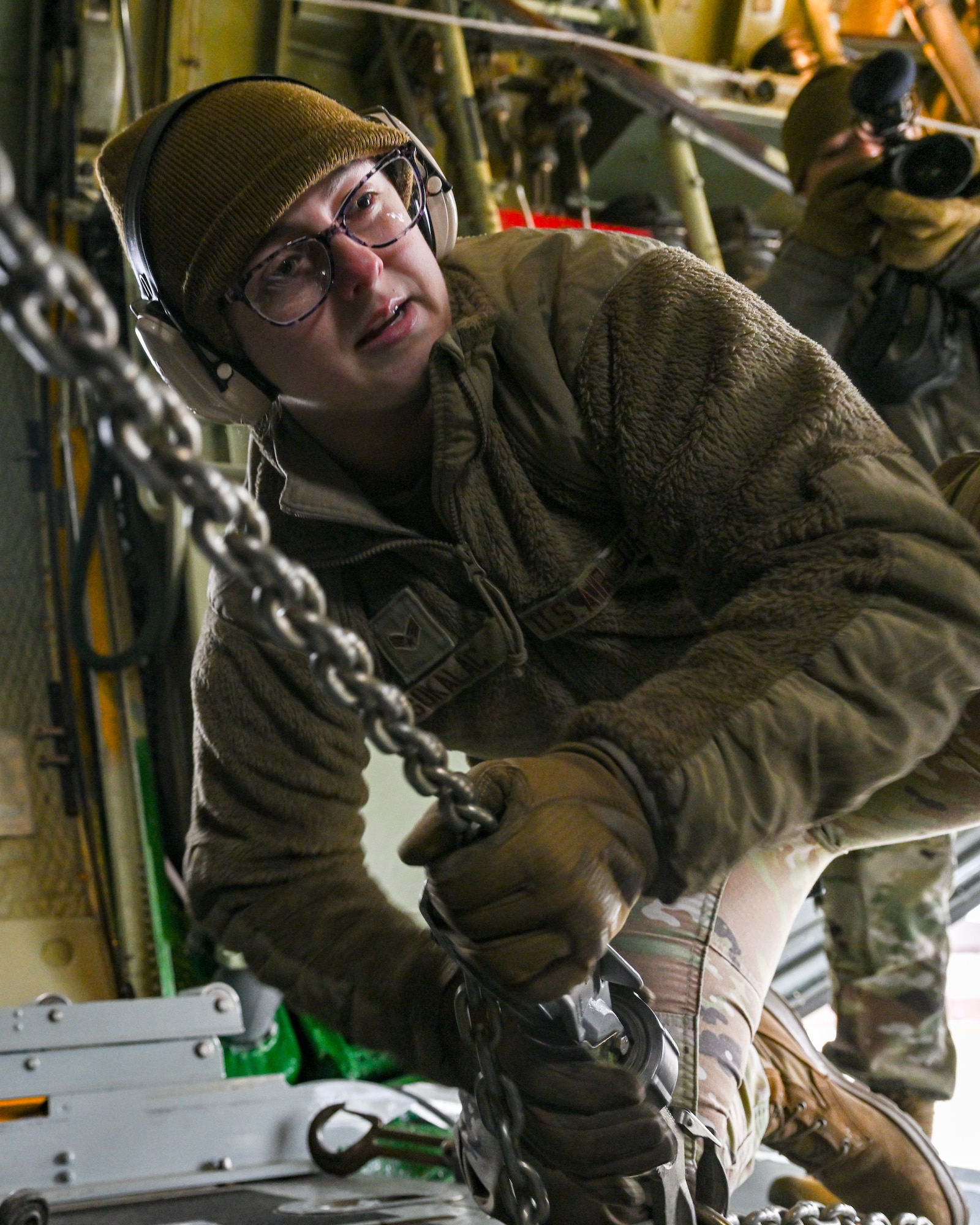 Senior Airman Haley Sukalac, a port dawg with the 76th Aerial Port Squadron, chains a Humvee down in the cargo bay of a C-130H Hercules aircraft stationed at Youngstown Air Reserve Station, Ohio, on Jan. 6, 2024.