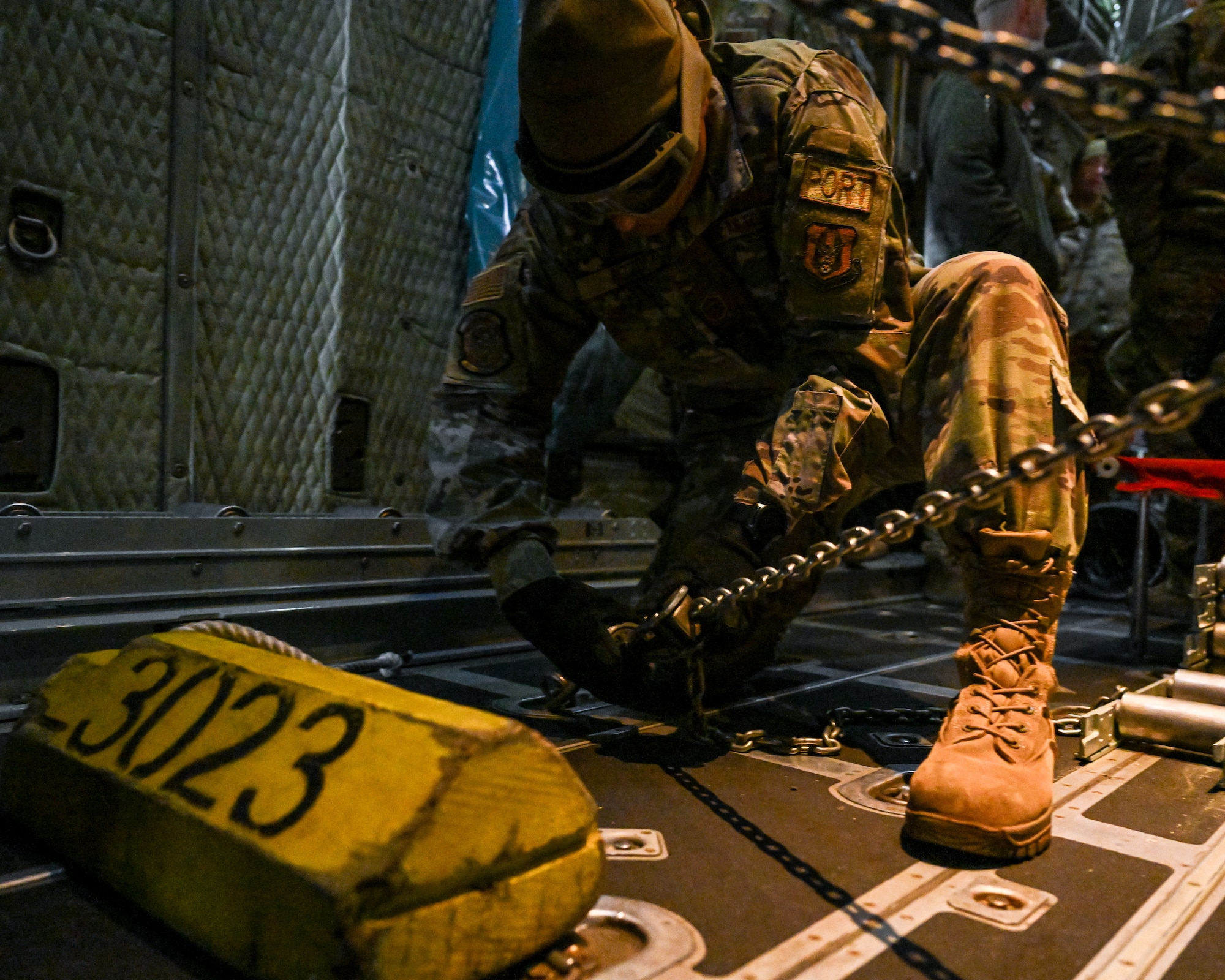 Master Sgt. John Rizzo, a port dawg with the 46th Aerial Port Squadron, Dover Air Force Base, Delaware, chains a Humvee down in the cargo bay of a C-130H Hercules aircraft stationed at Youngstown Air Reserve Station, Ohio, on Jan. 6, 2024.