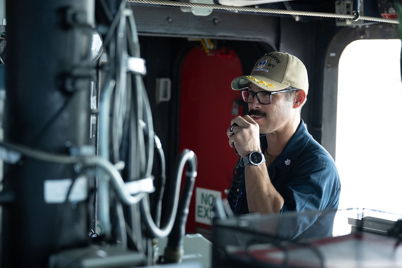 A person in uniform speaks into a microphone.