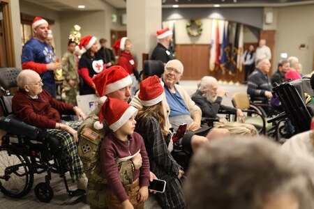 group of people sitting in an audience with Christmas outfits on.