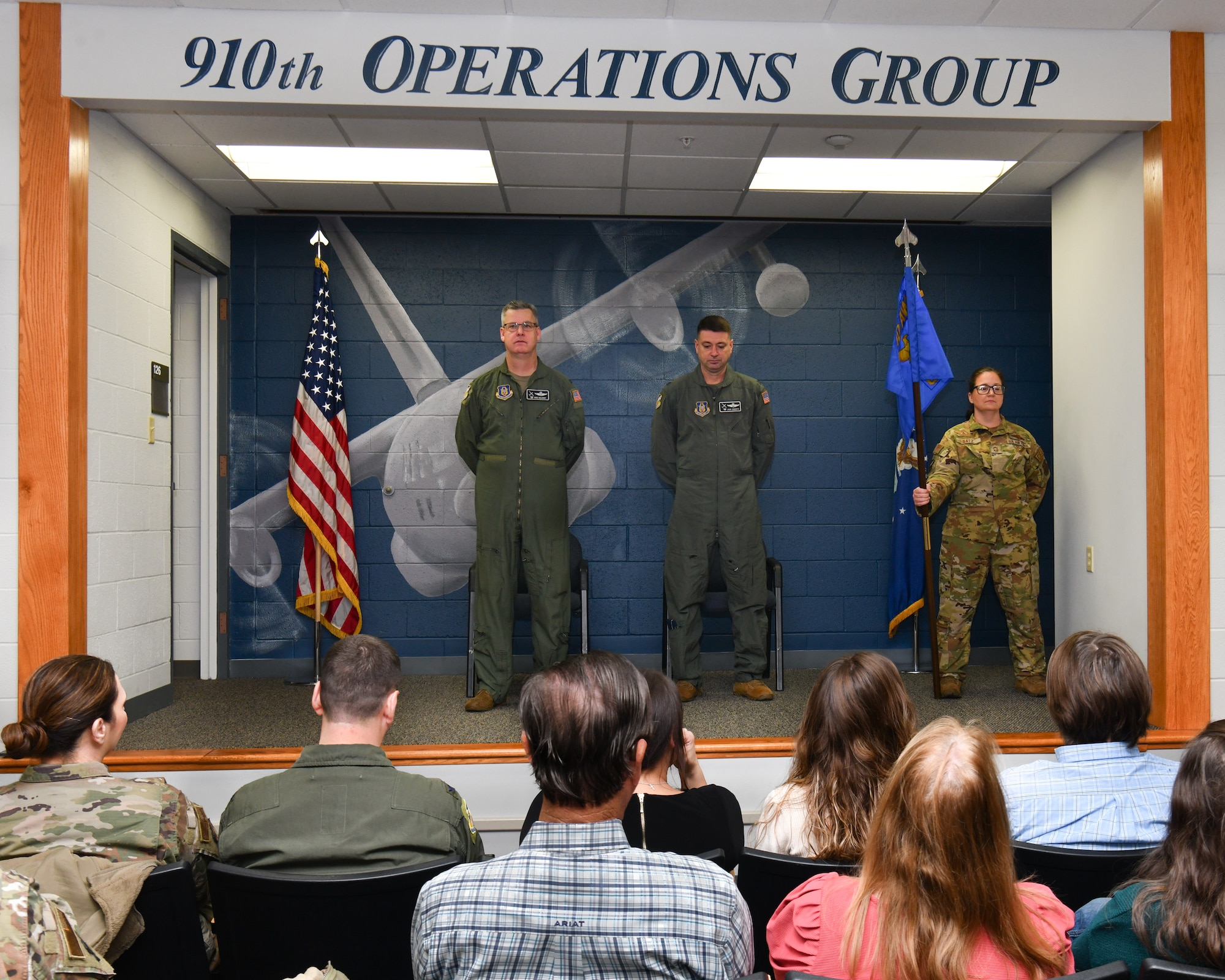 Col. Michael Maloney, commander of the 910th Airlift Wing, and Col. John Sebesta, incoming commander of the 910th Operations Group, listen to the historical significance of the guidon during Sebesta’s assumption of command ceremony on Jan. 6, 2024, at Youngstown Air Reserve Station, Ohio.