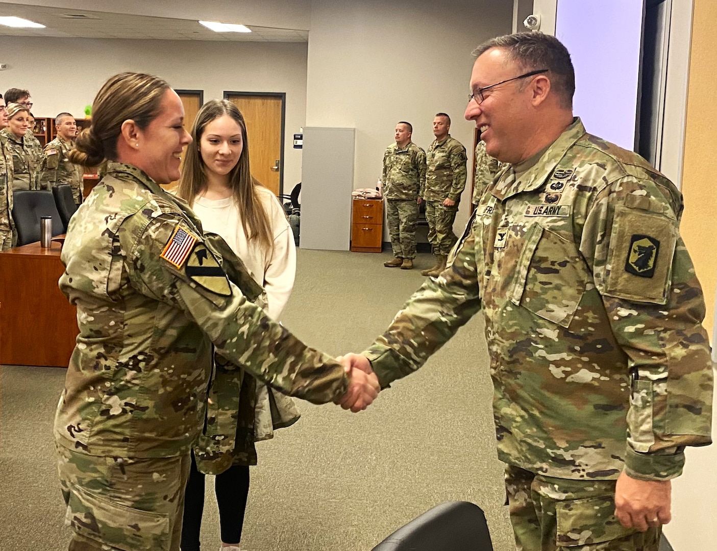Illinois Army National Guard Maj. Monica Perez of Mount Prospect, Ill., shakes hands with Col. David Helfrich, the commander of the 404th Maneuver Enhancement Brigade after Perez's promotion ceremony at the brigade headquarters on the Heartland Community College campus in Normal, Ill., on Nov. 18. Perez serves as the plans officer (S5) of the brigade.