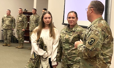 Illinois National Guard Maj. Monica Perez of Mount Prospect, Ill., shakes hands with Col. David Helfrich, the commander of the 404th Maneuver Enhancement Brigade after Perez's promotion ceremony at the brigade headquarters on the Heartland Community College campus in Normal, Ill., on Nov. 18. Perez serves as the plans officer (S5) of the brigade.