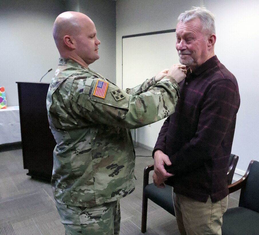 Samuel Staffan, U.S. Army Corps of Engineers, Mobile District transportation/fleet manager, receives his retirement pin from Lt. Col. Gary Cutler, Mobile District Deputy Commander, during a ceremony in Mobile, Alabama, Jan. 4, 2024. Staffan plans to spend time with fiancé Allie, his kids, and grandkids and to win the lottery in retirement. (U.S. Army photo by Chuck Walker)