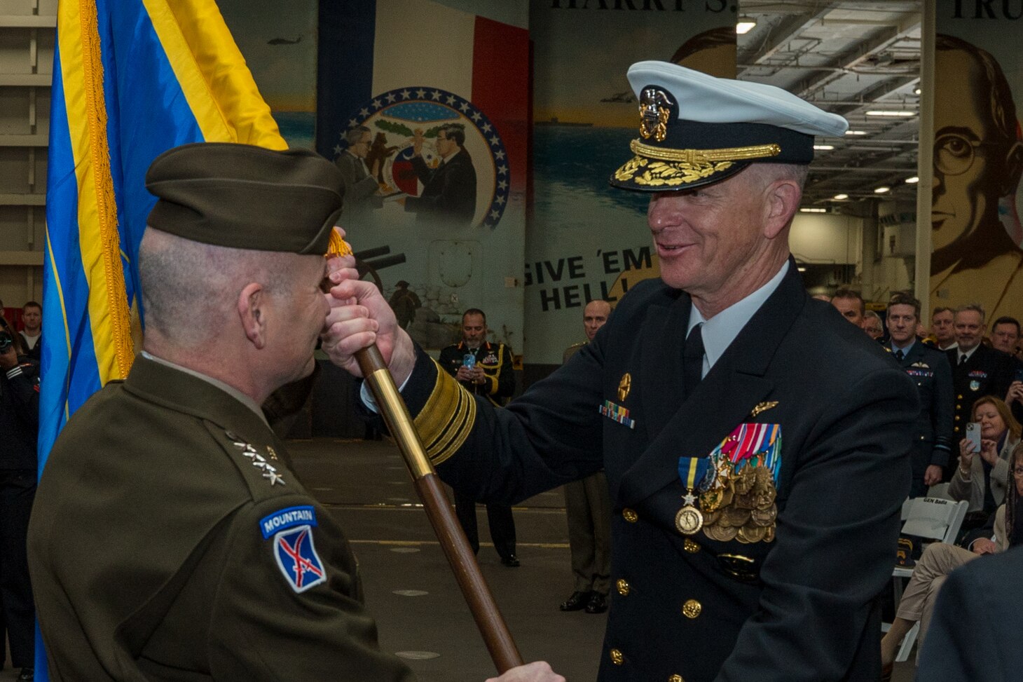 Vice Adm. Daniel Dwyer, commander, Joint Force Command Norfolk, passes the Joint Force Command Flag to Gen. Christopher Cavoli, Supreme Allied Command Europe commander during a change of command ceremony held aboard the Nimitz-class aircraft carrier USS Harry S. Truman (CVN 75), Jan. 12, 2024.