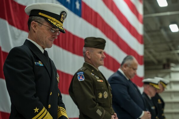 The official party for the Joint Force Command Norfolk, U.S. 2nd Fleet, and Combined Joint Operations from the Sea - Centre of Excellence change of command ceremony bow their heads in prayer during the ceremony held aboard the Nimitz-class aircraft carrier USS Harry S. Truman (CVN 75), Jan. 12, 2024.