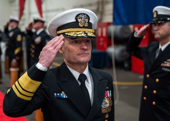 Vice Adm. Doug Perry salutes as he passes sideboys during a change of command ceremony aboard USS Harry S. Truman (CVN 75).