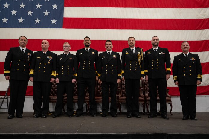 A photo of several men on stage posing for a picture.