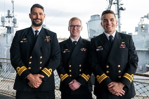 A photo of three men posing for a picture.