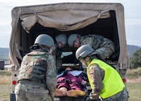 Airmen lift a simulated patient into a Humvee on Dec. 7, 2023, at Joint Base San Antonio-Camp Bullis, Texas, during Operation AGILE Medic. The joint exercise prepared medics with realistic hands-on experience promoting joint medical readiness. (U.S. Air Force photo by Senior Airman Melody Bordeaux)