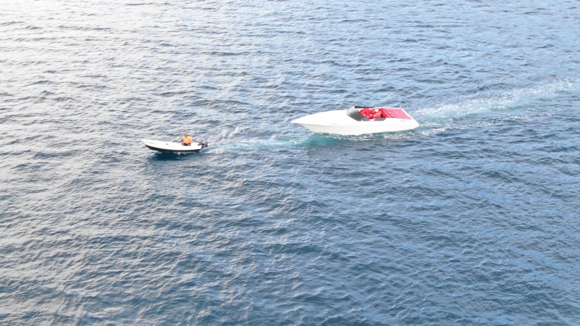 Coast Guard MH-60T Jayhawk aircrew flies over empty 30-foot white power boat in tow by another vessel during search for missing boater near Coki Point in St. Thomas, U.S. Virgin Islands, Jan. 14, 2024.  Coast Guard air and surface crews continue the search for Todman Davaughn, 51, who reportedly was the sole person aboard the vessel when he was ejected after crashing and spinning out of control several times. (U.S. Coast Guard photo)