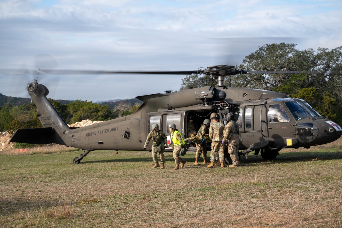 Airmen transport simulated patients from a UH-60 on Dec. 7, 2023, at Joint Base San Antonio-Camp Bullis, Texas, during Operation AGILE Medic. This joint force medical training exercise involves hands-on scenarios in an austere environment, providing medics with crucial experience in communication and diverse medical skills. (U.S. Air Force photo by Senior Airman Melody Bordeaux)
