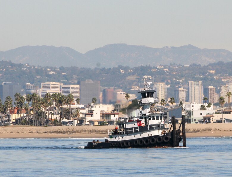 The Seana C, a triple-screw-model bow tug, makes its way from Marina del Rey Harbor, California, while pulling a dump scow, called the Robert L, to a nearshore area of Dockweiler State Beach in nearby Playa del Rey. The vessels are slated to make four to five trips per day for the next five months to complete this cycle of maintenance dredging for the entrance channel of Marina del Rey Harbor.