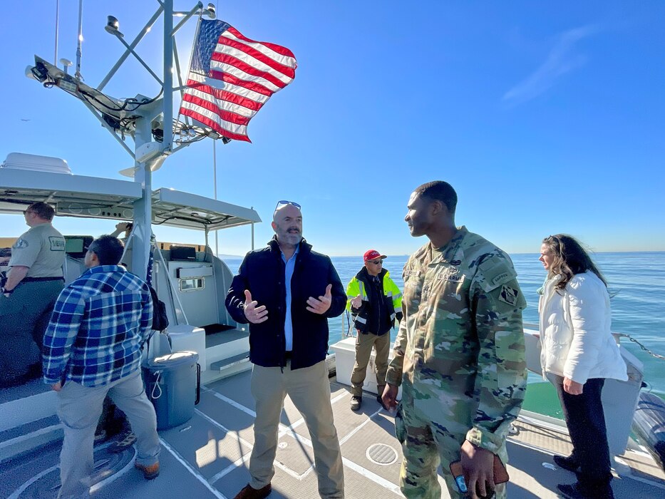 Gary Jones, director of the Los Angeles County Department of Beaches and Harbors, left of center, talks with Lt. Col. Stephen Brooks, U.S. Army Corps of Engineers Los Angeles District deputy commander, during a Jan. 9 boat tour of dredging operations at Marina del Rey Harbor in LA County, California. Brooks spent most of the day visiting with LA District project-delivery team members and LA County project partners to better understand how he can best support those working on the project.