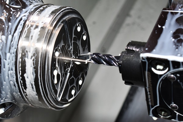 A lathe is photographed while manufacturing a part.