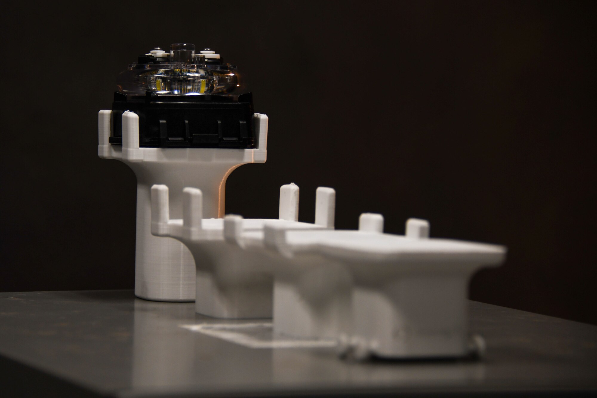 A progression of tactical lighting mount prototypes is shown at Altus Air Force Base, Oklahoma, Jan. 5, 2024. The mounts were designed and 3-D printed with the use of the Wing Innovation Advancement Center, also known as Spark Cell. (U.S. Air Force photo by Senior Airman Miyah Gray)