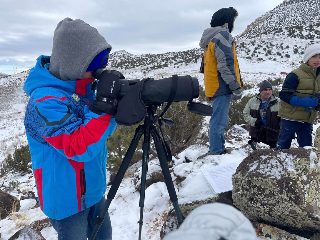 A volunteer looks for eagles through a telescope during the annual mid-winter bald eagle survey at Abiquiu Lake, N.M., Jan. 6, 2024.
