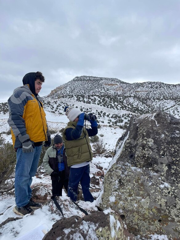 A volunteer looks for eagles with binoculars during the annual mid-winter bald eagle survey at Abiquiu Lake, N.M., Jan. 6, 2024.