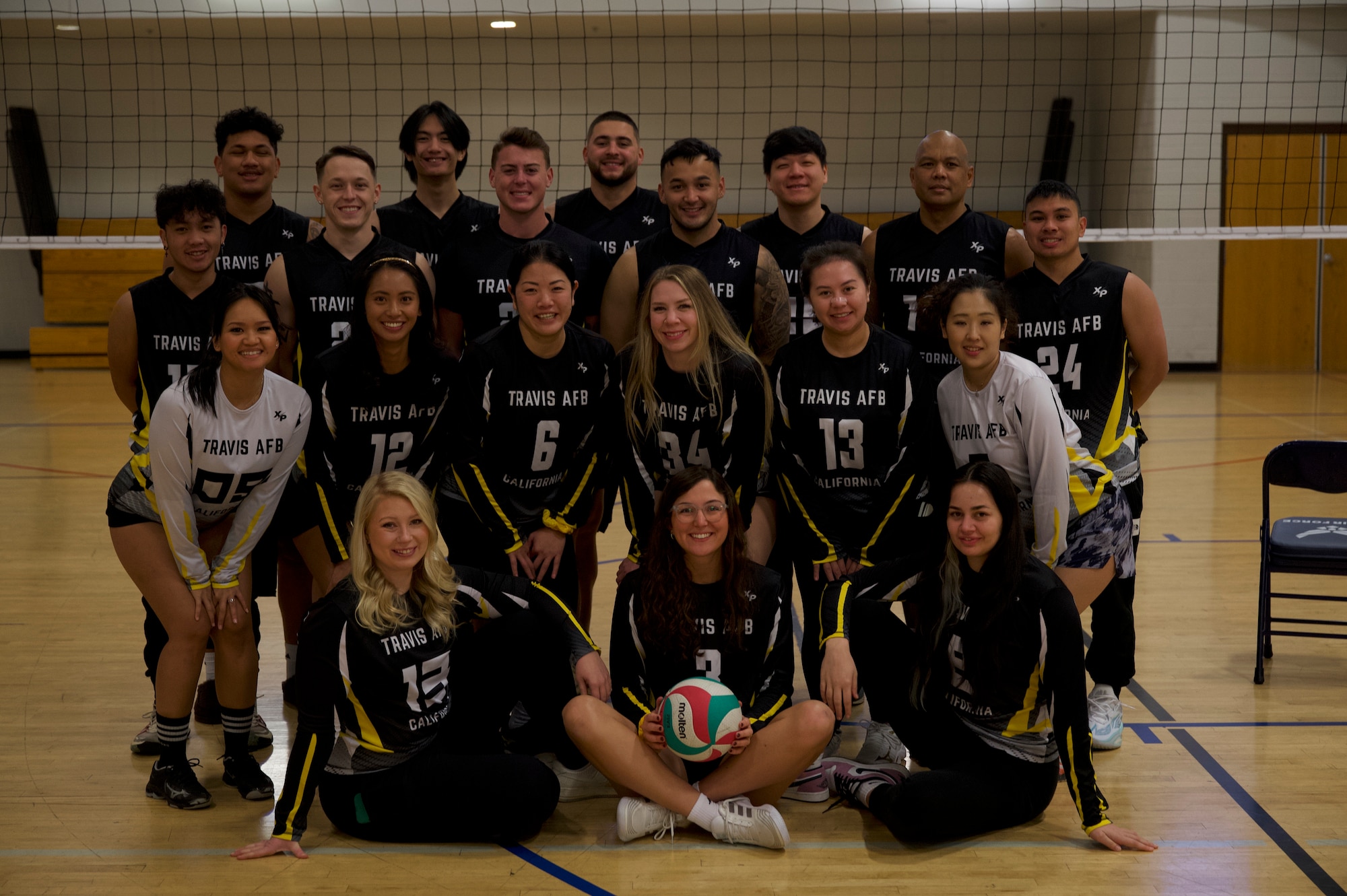 U.S. Airmen on the Travis Air Force Base volleyball team pose for a team photo at Davis-Monthan Air Force Base, Ariz., Jan. 14, 2024. The Travis Air Force Base volleyball team secured a win for the women’s and co-ed divisions of the regional tournament. (U.S. Air Force photo by Airman 1st Class Robert Allen Cooke III)
