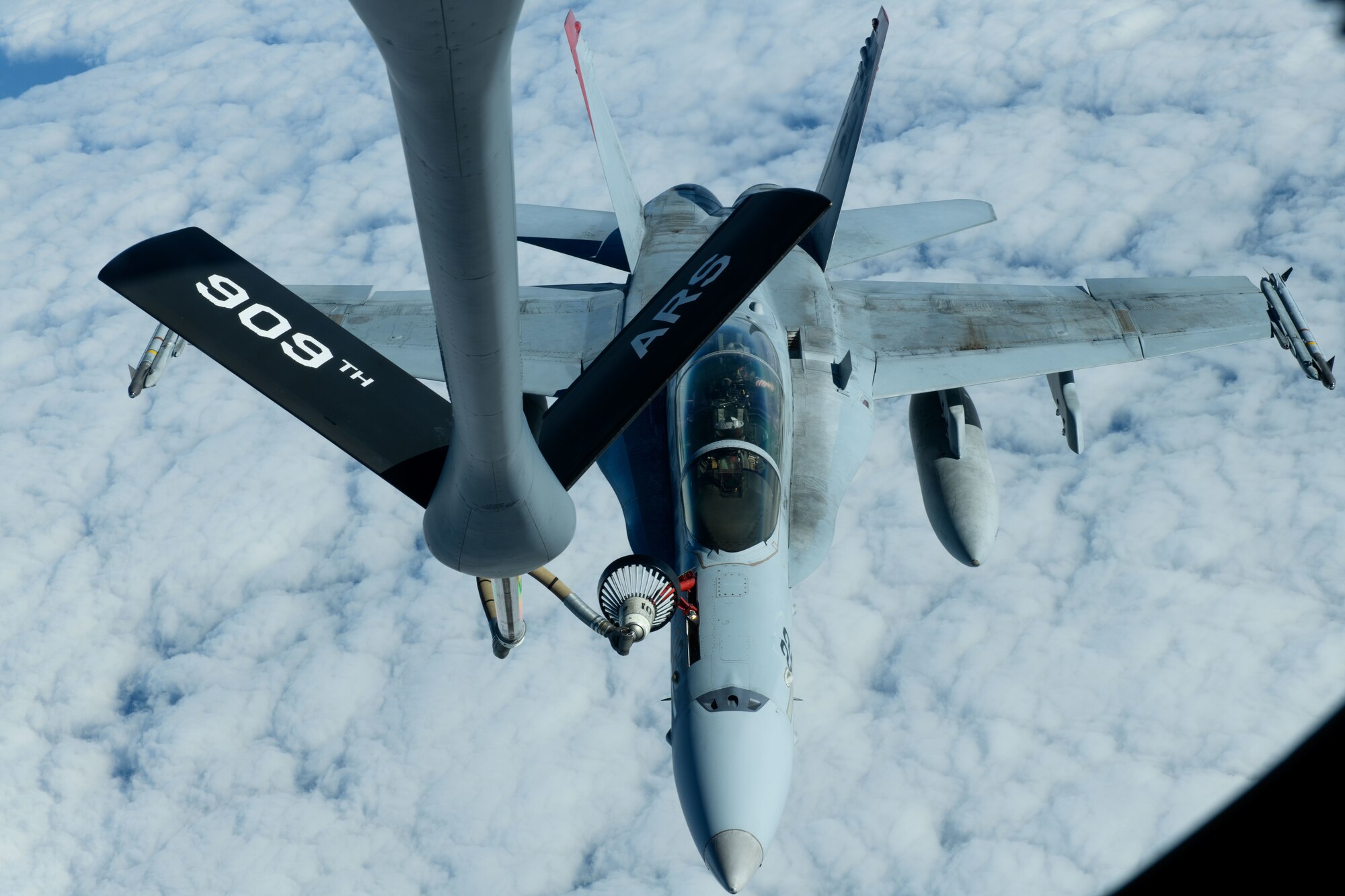 A U.S. Marine Corps F/A-18 Hornet is refueled by a U.S. Air Force KC-135 Stratotanker from Kadena Air Base over the Pacific Jan. 3, 2024. The 909th Air Refueling Squadron conducts joint operations throughout the Indo-Pacific region, demonstrating the critical role mobility forces have in projecting the joint force anywhere, anytime. (U.S. Air Force photo by Senior Airman Cedriue Oldaker)